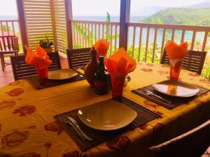 una mesa de madera con platos y botellas de vino. en La Villa Kanel en Les Anses-dʼArlets