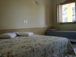 a bedroom with a bed and a window at Pousada Do Mestre in Pirenópolis