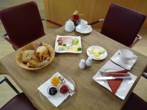 una mesa con un plato de pan y una cesta de comida en Cafe und Pension Blohm, en Greifswald