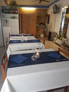 a group of tables with blue napkins on them at Hostal Pancheta in San Pol de Mar