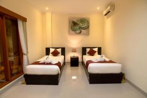 a room with two beds with towels on them at Tom's Inn Pecatu in Uluwatu +48 photos