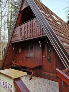 un edificio de madera con terraza y banco en KOČA PLANIKA, SVIŠČAKI, en Ilirska Bistrica