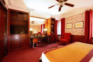 a hotel room with a large bed and a fireplace at Grand Hotel de l'Opera - BW Premier Collection in Toulouse