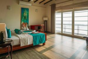 a bedroom with a bed and a large window at Twenty-Two Weligambay in Weligama