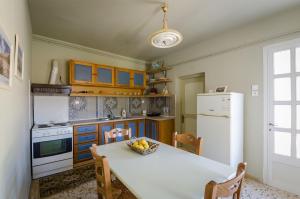a kitchen with a table with a bowl of fruit on it at Ev Zin Mouria in Leonidio