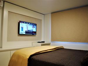 グラマドにあるApartamento Moderno Centro Gramadoのベッドルーム1室(ベッド1台、壁掛けテレビ付)