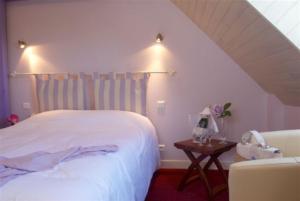 A bed or beds in a room at Logis Hotel Belle-Vue