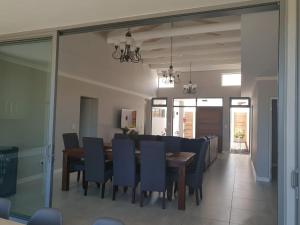 蘭格班的住宿－679 Morsvalla Way Langebaan Golf Estate，一间带桌子和蓝色椅子的用餐室