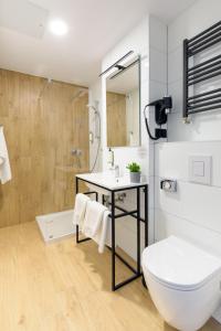 a bathroom with a toilet and a sink and a shower at Arche Hotel Lublin in Lublin