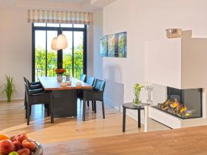 a dining room with a table and a fireplace at Waterview Cloud***** in Ostseebad Sellin
