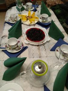 una mesa con servilletas verdes y un pastel. en Volna Hotel, en Alushta