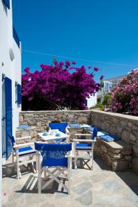 a table with chairs and a blue umbrella at Gryparis' Club Apartments in Mikonos