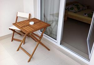 a wooden table and a chair in a room at Maris Pokoje Gościnne in Łeba