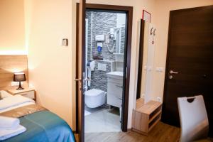 sypialnia z łóżkiem, toaletą i oknem w obiekcie Guest House Vila Moj Mir w mieście Rateče