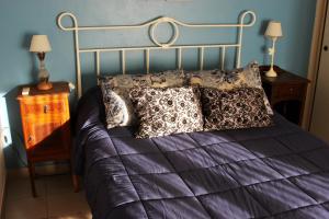 a bed with purple sheets and pillows in a bedroom at Via Pringles Cabañas Boutique in Sierra de la Ventana