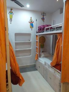 um quarto com 2 beliches com cortinas cor de laranja em Banaras Guest House em Varanasi