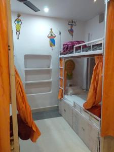 a room with two bunk beds with orange curtains at Banaras Guest House in Varanasi