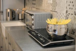 a kitchen counter with a pot of pasta on a microwave at Dimora Sant'Angelo in Montescaglioso