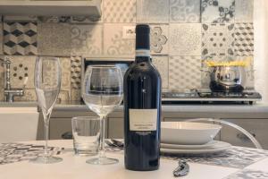 a bottle of wine sitting on a table with two glasses at Dimora Sant'Angelo in Montescaglioso +40 photos