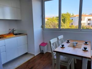 a kitchen with a wooden table and chairs and two windows at Apartment IVANA in Novalja +2 photos