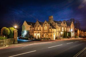 una casa grande al lado de una calle por la noche en Best Western The Shrubbery, en Ilminster