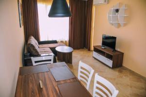 a living room with a couch and a table and a television at Apartments in RIF 3 in Ravda