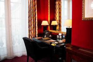 Habitación roja con escritorio y pared roja. en Grand Hotel de l'Opera - BW Premier Collection en Toulouse