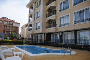 a swimming pool in front of a building at Apartments in RIF 3 in Ravda