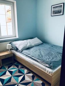 a bed sitting in a room with a window at Apartamenty Kilińskiego in Ustka