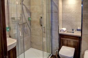 a bathroom with a shower, toilet and sink at Best Western Kings Manor in Edinburgh