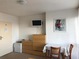 a room with a table and a tv on a wall at Penzion Panorama in Beroun