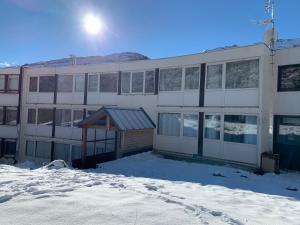 un bâtiment avec de la neige devant lui dans l'établissement Studio des Cintes Blanques, à Aragnouet