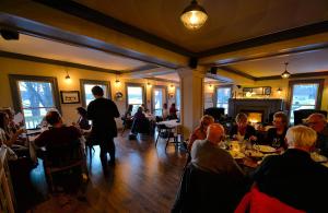 a group of people sitting at tables in a restaurant at Lanes Privateer Inn in Liverpool