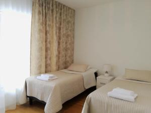 two twin beds in a room with a window at Marina Holiday Rauhan Village Apartments in Imatra