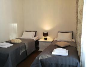a room with two beds and a table with a lamp at Marina Holiday Rauhan Village Apartments in Imatra