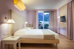 a bedroom with a large bed and a window at Hotel Kristal Palace - Tonelli Hotels - Adult Friendly in Riva del Garda