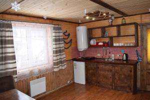 a kitchen with wooden cabinets and a window at Котедж Віадук in Vorokhta