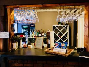 un bar con copas de vino colgando sobre un mostrador en Brunsbo G:a Biskopsgård Hotell & Konferens, en Skara