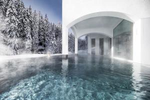 a pool of water in a building with trees at Mooser Hotel in Sankt Anton am Arlberg