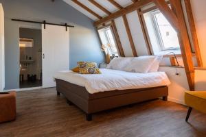 um quarto com uma cama com almofadas em Hostellerie Horst em Horst