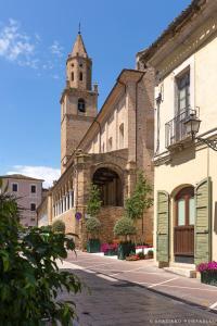 um edifício antigo com uma torre de relógio numa rua em Alloggio nonna Cornelia em Citta' Sant'Angelo