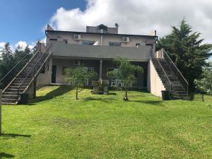 una casa grande con escaleras en un patio en Ommbungalows en Colón