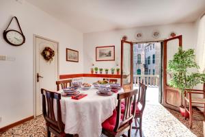 comedor con mesa, sillas y reloj en CasaMisa Formosa 5193 en Venecia