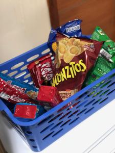 a blue basket filled with chips and other snacks at Hotel Flor de Lotus in Santa Isabel do Pará