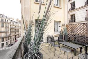 a balcony with a bench and chairs and plants at Apartment Opéra / Galeries Lafayette in Paris