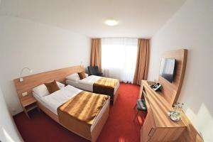 a hotel room with two beds and a television at Alexandra Šport Hotel in Púchov