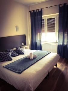 a large bed with a towel on top of it at Logis Le Provençal in Euville