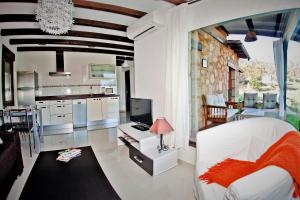 a living room with a white couch and a kitchen at Apartamentos El Roble in Valverde de la Vera