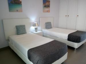 クアルテイラにあるMamamia AC&Vista Magnificaのベッドルーム1室(ベッド2台、テーブルの上にランプ付)
