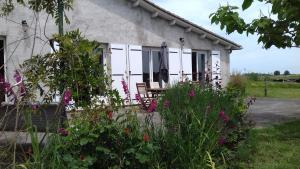 ein Cottage mit Blumen davor in der Unterkunft La maison d'Augusta in Saint-Martin-de-Coux